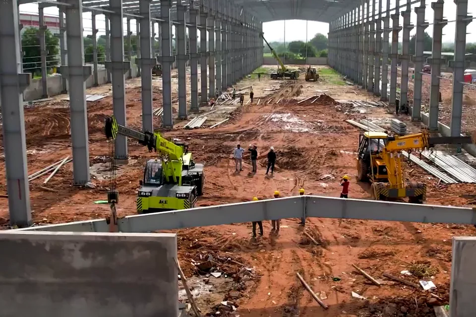Inside the Allmarc AM InfraCon shed while its steel frame goes up, with two cranes at work